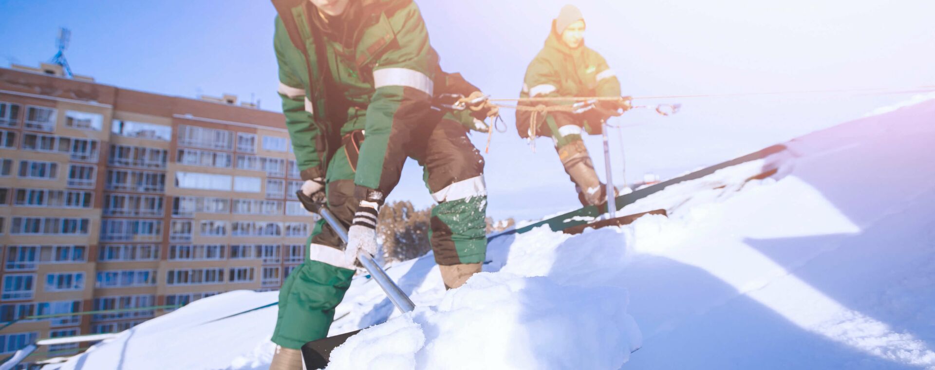 MEGLA: Menschen entfernen den Schnee von einem Dach